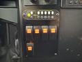 The image shows the control panel of a 2011 Ford F-550 featuring various toggle switches for door lights heater and defrost functions