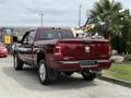 A red 2024 RAM 3500 Limited pickup truck with chrome accents and a spacious cab is shown from the rear angle with a visible brand emblem on the tailgate