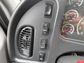 Dashboard controls of a 2019 Freightliner M2 featuring buttons for speed control and air conditioning along with gauges for temperature and transmission fluid levels