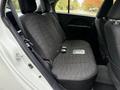 A white 2013 Mitsubishi i-MiEV with a spacious rear seat featuring black fabric upholstery and seat belts