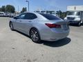 A silver 2017 Acura TLX parked with a sleek design featuring a curved roofline and attractive alloy wheels