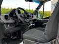 Interior view of a 2019 Mercedes-Benz Sprinter showing the driver's seat steering wheel and dashboard with control buttons and cup holders