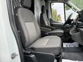 Two gray front seats of a 2022 Ford Transit with armrests and a steering wheel visible in the cabin interior