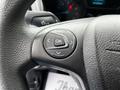 Close-up of a steering wheel control panel from a 2016 Ford Transit Connect featuring navigation and selection buttons