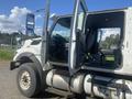 A 2014 International 7400 truck with both front doors open revealing the driver's cabin and seating area