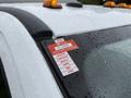 A 2018 Ford F-550 with a red certificate of approval sticker on the windshield showing the months of the year and an identification number