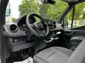 Interior view of a 2020 Mercedes-Benz Sprinter showing the steering wheel dashboard and front seats with cup holders