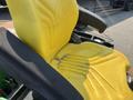 A close-up of a yellow seat from a 2012 John Deere 1445 Series II 4WD tractor showing worn texture and design details