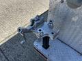A silver coupler attachment for a 2004 Freightliner M2 mounted on a vertical post with a clamping mechanism and handles for secure connection