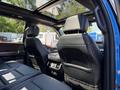 Interior view of a 2021 Ford F-150 showing the rear seats and panoramic sunroof with leather upholstery and a central console