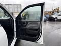 A 2015 GMC Sierra 1500 with its driver's side door open showcasing the interior handle and armrest
