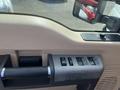 A close-up view of the interior door panel of a 2014 Ford F-350 SD featuring window control buttons and a handle