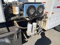 Close-up of a 2007 International 7300 truck's air conditioning unit featuring two fans and various connected hoses and components