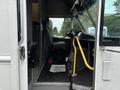 A 2018 Ford Econoline interior with a driver's seat visible along with a yellow handrail and floor mat that says Thank You You