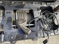 A close-up view of a winch mounted on a 2015 Ford F-550 showing a coiled steel cable and a control handle with wires attached
