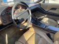 Interior view of a 1983 Porsche 928 featuring a leather steering wheel beige seats and a dashboard with various gauges and controls