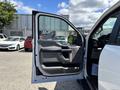 A 2016 Ford F-150 with an open driver's side door showing the interior door panel and control buttons