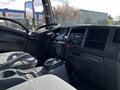 Interior view of a 2016 Isuzu NPR featuring a driver’s seat steering wheel gear shift and dashboard controls