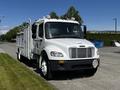 A 2004 Freightliner M2 truck with a gray and white body featuring a utility bed and multiple tool compartments