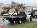 A 2008 Sterling Bullet flatbed truck with a black bed and metal side rails parked in an outdoor area. The truck has a white cab and is designed for transporting cargo.