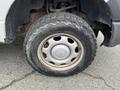 A close-up of a tire and wheel from a 2010 Ford F-150 showing rugged tread and a silver hubcap