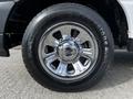 Close-up of a chrome rim with a Ford logo and a Firestone tire on a 2010 Ford Ranger