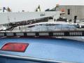 A 2009 Ford Econoline with a light bar mounted on the roof displaying multiple LED lights