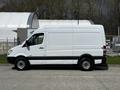 A white 2012 Mercedes-Benz Sprinter van with a high roof and sliding side door parked in a lot