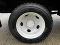 Close-up of a large tire mounted on a white wheel for a 2013 Ford F-650 showcasing deep treads and a sturdy design