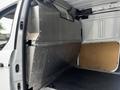 A 2014 Ford Transit Connect interior featuring a metal dividing wall and a flat black floor surface