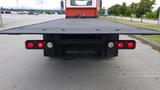 A 2015 International DuraStar 4300 with a flatbed and red tail lights visible from the rear