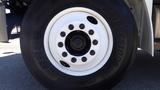 Close-up of a white wheel with black lug nuts on a 2015 Freightliner M2 106 tire showcasing the tire tread and rim design