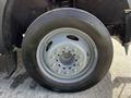Close-up of a gray steel wheel with a five-bolt pattern featuring a large black tire labeled 25570R19.5 mounted on a 2008 Ford F-550