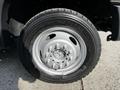 Close-up of a silver wheel from a 2016 Ford F-550 with a black tire displaying the size 235/70R19.5 and several metal bolts in the center hub