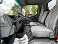 Interior view of a 2016 Isuzu NPR showing two grey cloth seats and a steering wheel with a dashboard in the background