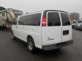 A white 2011 Chevrolet Express van with tinted windows and silver wheels positioned at an angle showing the rear and side view