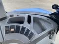 Dashboard controls of a 2016 New Holland T475 tractor featuring multiple switches and a compartment for storage