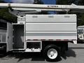 A white 2012 Freightliner M2 106 bucket truck with a Terex aerial lift and a storage compartment on the side