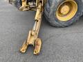 A yellow John Deere 310SJ backhoe loader with a hydraulic arm and a bucket attachment on the ground