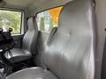 Interior view of a 2016 International 7600 featuring two gray leather seats positioned side by side with a steering column and controls visible in front
