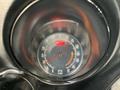 A close-up view of a vintage car speedometer featuring a circular design with a black background and red markings indicating speed and RPM
