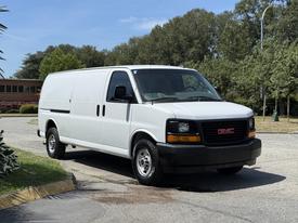 A 2016 GMC Savana van in white parked with a sleek front design and understated features