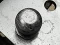 A close-up of a round hitch ball mounted on a metallic surface with engraved weight markings
