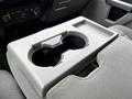 A gray plastic cup holder with two circular slots located in the center console of a vehicle interior