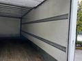Interior of a 2020 Hino 338 truck showing wooden flooring and metal tie-down tracks along the walls