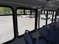 Interior view of a 2017 Chevrolet Express bus showing rows of blue upholstered seats and large windows
