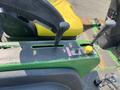 The control panel of a 2012 John Deere 1445 Series II 4WD featuring levers for operation and a yellow knob for adjustments