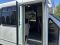 A 2020 Chevrolet Express van with an open side door revealing spacious interior seating and handrails