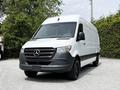 A 2023 Mercedes-Benz Sprinter van with a white exterior and a black front grille parked in a lot