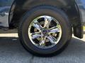 A close-up of a chrome rim and tire from a 2015 Ford F-150 showcasing a shiny multi-spoke design and thick rubber tread